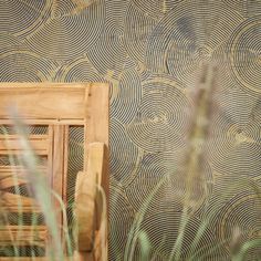 a wooden frame sitting in front of a wall with an artistic pattern on it's side