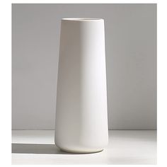 a white vase sitting on top of a table