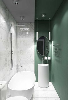 a modern bathroom with green walls and white fixtures on the wall, along with two round sinks