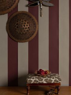 a room with striped wallpaper and a bench on the floor in front of it