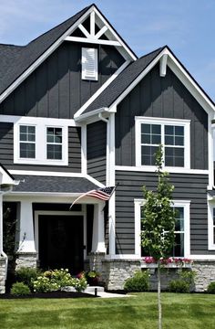 a large gray house with white trim and windows