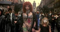 a group of people walking down a street next to each other with makeup painted on them