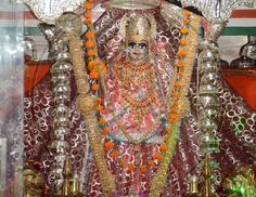 an idol is displayed in front of other items and decorations on the wall behind it