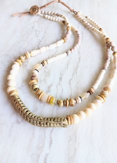 Bring elegance to every outfit you wear this with...amazing on everything linen, everything neutral or black. A standout piece! A variety of Picture Jasper, Natural Jasper, White Turquoise, Fossilized Coral, natural Howlite, bone beads, bone disks, mixed metal accents, and more. Focal is an Ashanti Ghana brass mesh tube bead with a slight elbow. Great texture and interest. Strung on Beadalon .018 7-strand Stainless Steel Bead Stringing wire-great strength and great flexibility. Unique shell and leather suede loop closure, extendable. Mixed media, shell, wood, and saucer beads. One-of-a-kind. The item/s pictured is the item you will receive. HavSolStudio on ETSY | Mixed media . Earthy elegance . Great texture . Beach inspired . Coastal calm . A little rustic . Worldly . Alluring . Recycled White Bohemian Beaded Necklaces For Layering, Bohemian Beaded Necklaces With Colorful Beads In Beige, Bohemian Beige Beaded Necklaces With Natural Stones, Earthy Beige Jewelry For Everyday Wear, Earthy Everyday Beige Jewelry, Brass Mesh, Fossilized Coral, Bone Beads, White Turquoise