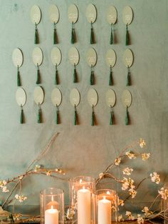 several candles are lit in front of a wall decoration