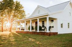 a white house sitting on top of a lush green field