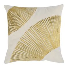 a gold and white pillow with an abstract design