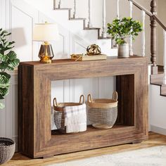 a wooden table with baskets and plants on it in front of the stairs, next to a stair case