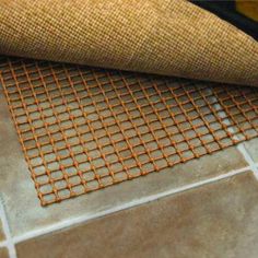 a close up of a mat on the floor next to a rug with an orange mesh covering it