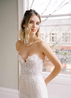 a woman in a wedding dress posing for the camera