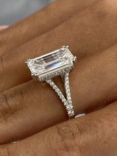 a woman's hand holding an engagement ring with a large diamond in the center