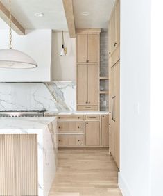 a kitchen with marble counter tops and wooden cabinets