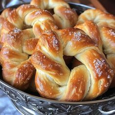 a metal bowl filled with croissants covered in powdered sugar