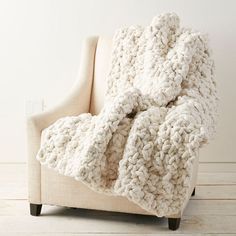 a white blanket sitting on top of a chair