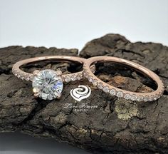 two wedding rings sitting on top of a rock