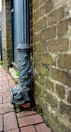 the corner of an old brick building with a metal pole on it's side