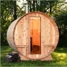 a wooden barrel sauna in the grass