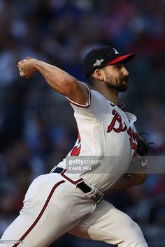 a baseball player pitching a ball in the middle of a pitch with his arm out