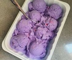 purple ice cream in a plastic container with a spoon