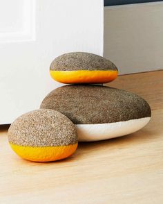 two brown and white rocks sitting on top of a wooden floor next to a door