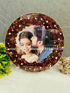 a plate with an image of a man and woman on it sitting next to flowers