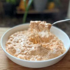 a white bowl filled with oatmeal sitting on top of a wooden table