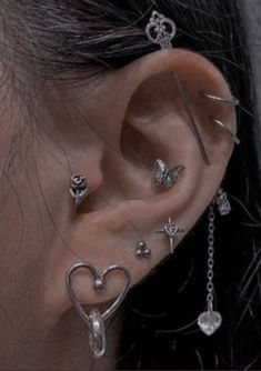 an ear with multiple piercings attached to it's sides and two hearts on each side