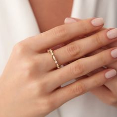 a woman's hand wearing a gold ring with diamonds on the middle and sides