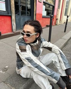 a woman sitting on the ground wearing sunglasses