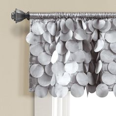 a window curtain with white circles hanging from it's side