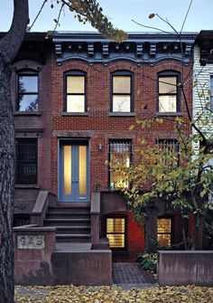 an old brick building with stairs leading up to the front door and second story windows