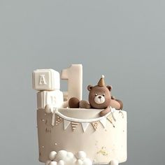 a birthday cake with a teddy bear in the top and number one on it's side