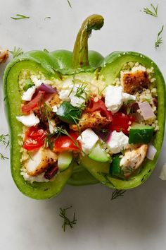 a green bell pepper stuffed with chicken, vegetables and feta cheese on it's side