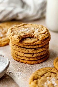 a stack of cookies sitting on top of a table next to a glass of milk