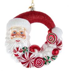 a santa clause ornament hanging on a christmas wreath with red and white candy canes