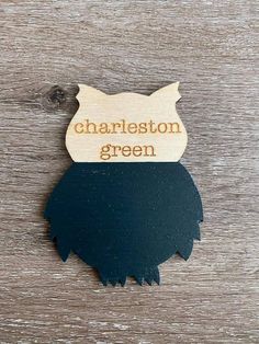 a wooden sign that says charleston green with an image of a cat's head