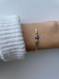 Brush away negative energy and stay protected with this dainty evil eye bracelet! D E T A I L S *It features a gold filled evil eye charm (12 x 6.5mm) in traditional blue *on a high quality 18k gold filled Figaro chain in yellow gold. *Gold filled is a wonderful alternative to solid gold and unlike gold plating does not rub off. *A tiny gold filled cross dangles from the chain. *It closes with a gold filled lobster clasp. *Choose the length from the drop down menu. Use the length guide as a reference to help you get the right size. Bracelet needs to be snug to stop it rolling. C A R E * T I P :  To keep your bracelet in great condition avoid contact with water, perfume and chemicals. Also remove when exercising and sleeping . P A C K A G I N G: All our products are gift ready. T E R M S* O Gold Spiritual Evil Eye Bracelet For Everyday, Gold Spiritual Evil Eye Bracelet With Adjustable Chain, Dainty Gold Evil Eye Bracelet, Gold Dainty Evil Eye Bracelet With Adjustable Chain, Dainty Evil Eye Bracelet With Adjustable Chain, Dainty Gold Evil Eye Bracelet With Adjustable Chain, Dainty Yellow Gold Bracelet With Evil Eye Detail, Dainty Yellow Gold Bracelet With Evil Eye, Dainty Blue Evil Eye Bracelet