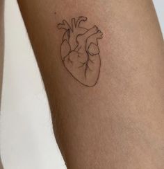 a small tattoo of a human heart on the right side of the leg, which is black and white