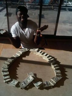 a man sitting in front of a pile of money