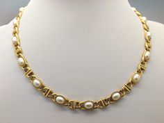 Hello and welcome to my shop. I am offering to you this very fine classic modern design costume jewelry necklace. As you will see in the pictures it is made in a chunky goldtone metal chain and set along its length with oval faux pearls. The clasp is a foldover open clasp type in good working condition.  The goldtone and pearl necklace is in excellent used vintage condition with no to very slight age related surface wear as shown.  So please see my six pictures as they are part of my description Exquisite Yellow Gold Pearl Necklace, Luxury Gold-tone Necklace With Polished Finish, Luxury Gold-tone Oval Link Necklace, Luxury Gold-tone Elegant Pearl Necklace, Elegant Gold-colored Brass Pearl Necklace, Costume Jewelry Necklaces, Metal Chain, Costume Design