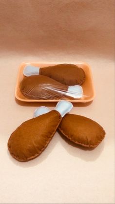 two pieces of bread on a plate with plastic wrappers in the shape of dogs