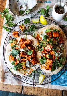 two pita breads with chicken and cilantro garnish on top