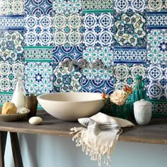 a bathroom with blue and white tiles on the wall, including a bowl, soap dish, toothbrush holder, bracelets and other accessories