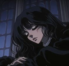 a woman with long black hair laying on top of a bed next to a window