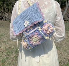 a woman is holding a crocheted purse