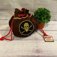 a small bag with a skull and crossbones on it next to a potted plant