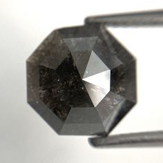 a black diamond sitting on top of a piece of metal