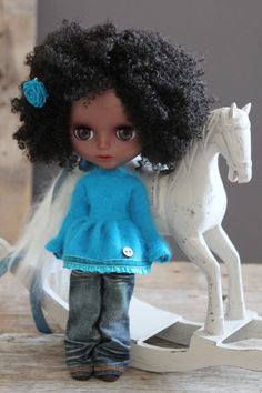 a doll is standing next to a toy horse