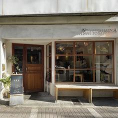 an outside view of a restaurant with benches and tables in front of the entrance door