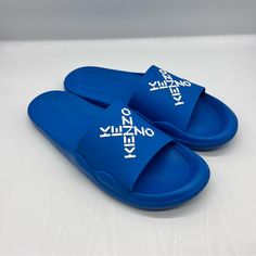 These Pool Slide Sandals Feature A Criss-Cross Kenzo Logo Design Across The Strap With A Textured Footbed. Synthetic Upper Open Toe Slip On Synthetic Sole Imported Blue Sandals With Rubber Sole For Vacation, Blue Slides With Branded Insole And Round Toe, Blue Open Toe Slides With Cushioned Footbed, Blue Casual Slides With Branded Insole, Blue Open Toe Slides With Rubber Sole, Sporty Blue Slide Sandals, Blue Open Toe Sporty Slides, Blue Synthetic Open Toe Slides, Blue Sporty Non-slip Slides